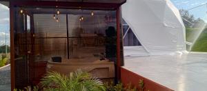 een huis met een glazen wand en een witte tent bij La cabaña de Ciela Glamping con jacuzzi in Latacunga