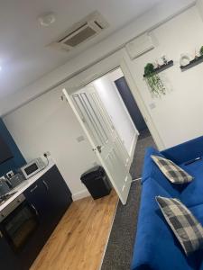 un soggiorno con un divano blu e una cucina di Blissfull dreams 1 bedroom apartment a Hull
