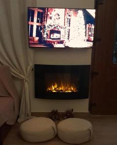 ein Wohnzimmer mit einem Kamin und einem TV darüber. in der Unterkunft Pelion Malaki- Casa Verde in Malaki