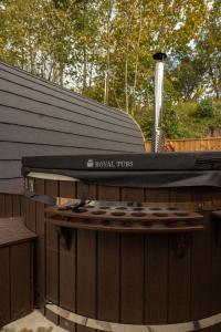a barbecue grill sitting on top of a wooden fence at livi pod Woodland lake in Carlton Miniott