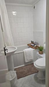 a bathroom with a tub and a toilet and a sink at Wellington Modern Studio - Free Parking in Wellington