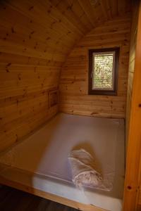 a bed in a wooden room with a window at livi pod Woodland lake in Carlton Miniott