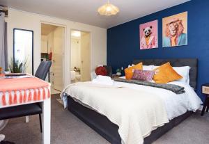 a bedroom with a bed and a blue wall at Wellington Modern Studio - Free Parking in Wellington