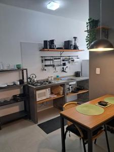 une cuisine avec une cuisinière et une table à l'intérieur dans l'établissement Flats das Palmeiras, à Florianópolis
