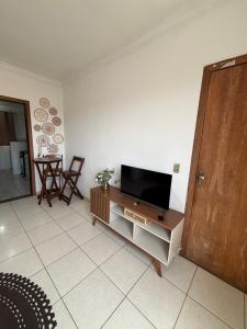 a living room with a flat screen tv on a cabinet at Apartamento próximo ao inhotim in Brumadinho