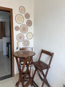 a table and two chairs and plates on a wall at Apartamento próximo ao inhotim in Brumadinho