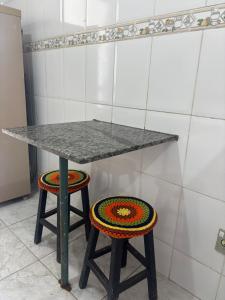 a table and two stools in a kitchen at Apartamento próximo ao inhotim in Brumadinho +9 photos