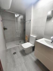 a bathroom with a shower and a toilet and a sink at Apartamento Florazar 2, 8ºC in Cullera