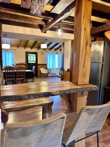 ein Wohnzimmer mit Holzböden und Stühlen sowie eine Küche in der Unterkunft Alma Andina in El Calafate