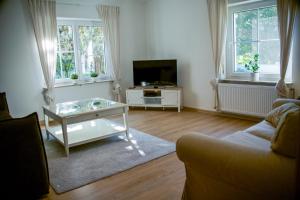 a living room with a couch and a table and a tv at Ferienwohnung Peters (EG) in Hünfeld