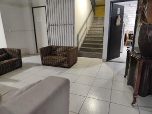 een woonkamer met twee stoelen en een trap bij Quarto casal in Cianorte