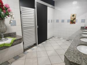 een badkamer met twee wastafels en een deur met bloemen bij Quarto casal in Cianorte