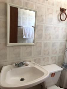 a bathroom with a sink and a toilet and a mirror at Chalet Bordemar in Concón