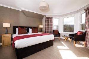 a hotel room with a bed and a desk and chairs at Derrybeg Bed and Breakfast in Pitlochry