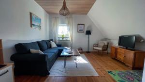 a living room with a blue couch and a tv at Ferienwohnung Peters in Hünfeld
