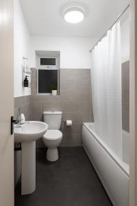 une salle de bain avec toilettes, lavabo et baignoire dans l'établissement Stylish Platt bridge contractor Stays, à Abram