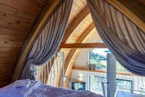 a bedroom with a bed and a large window at Perch on the Ridge by Waiheke Pure in Waiheke Island