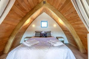 a bedroom with a bed in an attic at Perch on the Ridge by Waiheke Pure in Waiheke Island +4 photos