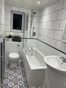 ein Badezimmer mit Badewanne, Toilette und Waschbecken in der Unterkunft Kingston Park House - Airport - Red Bulls Rugby in Kenton