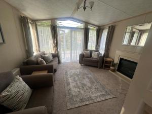 a living room with couches and a television and a fireplace at Glen-coo in Auchterarder