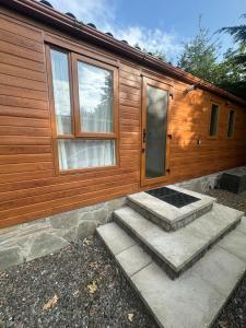 a wooden cabin with stairs leading to a door at Glen-coo in Auchterarder