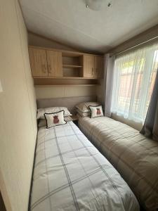 two beds in a small room with a window at Glen-coo in Auchterarder