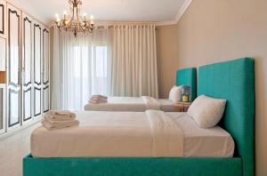 a bedroom with two beds and a chandelier at Zamalek Nile View in Cairo
