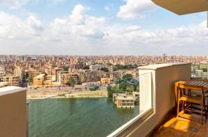 a balcony with a view of a river and buildings at Zamalek Nile View in Cairo