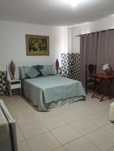a bedroom with a bed and a table at Pousada Tycoz Flor do mar in Galinhos