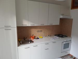 una cocina con armarios blancos y fregadero en Appartamento Federica, en Senigallia