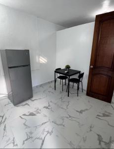 a dining room with a table and a refrigerator at Hospedaje paz y amor in San Juan