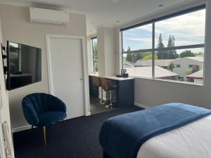 a hotel room with a bed and a large window at Hamilton Suites in Hamilton