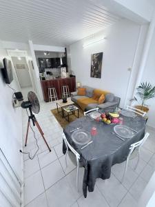 een woonkamer met een tafel en een bank bij Le Neo-Cayenne in Cayenne