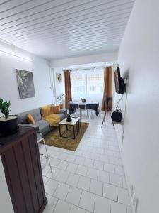 een woonkamer met een bank en een tafel bij Le Neo-Cayenne in Cayenne