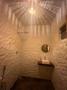 a white bathroom with a sink and a mirror at Mar Aberto Chalé 4 in Barroquinha