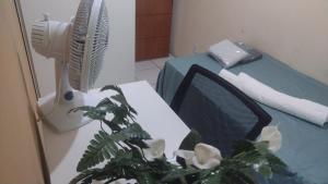 a room with a table with a fan and a plant at Quarto para cop30 em casa de família in Belém