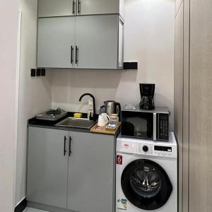 een keuken met een wasmachine en een magnetron bij نور هوستيل in Riyad