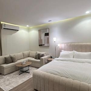 een slaapkamer met een groot bed en een bank bij نور هوستيل in Riyad