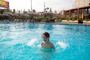 a young child is in a swimming pool at Casa Andina Standard Chincha in Chincha Alta