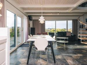 een eetkamer met een tafel en witte stoelen bij Luxury Panoramic Cottage in Rindby-By Traum in Fanø +26 foto's