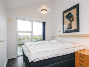 een slaapkamer met een groot bed en een raam bij Luxury Panoramic Cottage in Rindby-By Traum in Fanø