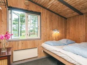 a bedroom with a bed in a wooden wall at Seaside Escape in Sonderho - By Traum Ferienwohnungen in Fanø