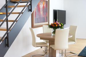 a dining room with a wooden table and white chairs at L19 Tuttlingen in Tuttlingen