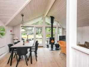 a dining room with a table and chairs and a fireplace at 8 person holiday home in Fanø-By Traum in Fanø