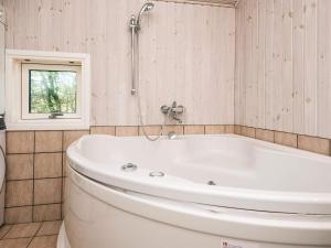 a white tub in a bathroom with a window at 8 person holiday home in Fanø-By Traum in Fanø