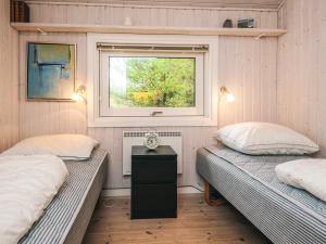 two twin beds in a room with a window at 8 person holiday home in Fanø-By Traum in Fanø