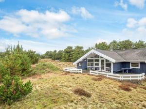 a blue house sitting on top of a hill at 8 person holiday home in Fanø-By Traum in Fanø
