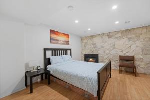 una camera da letto con un letto e un muro di pietra di Renovated North Vancouver Gem a North Vancouver
