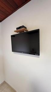 a flat screen tv hanging on a white wall at GO Hotelaria in Búzios