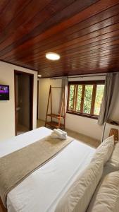 a bedroom with two beds in a room with wooden ceilings at GO Hotelaria in Búzios
